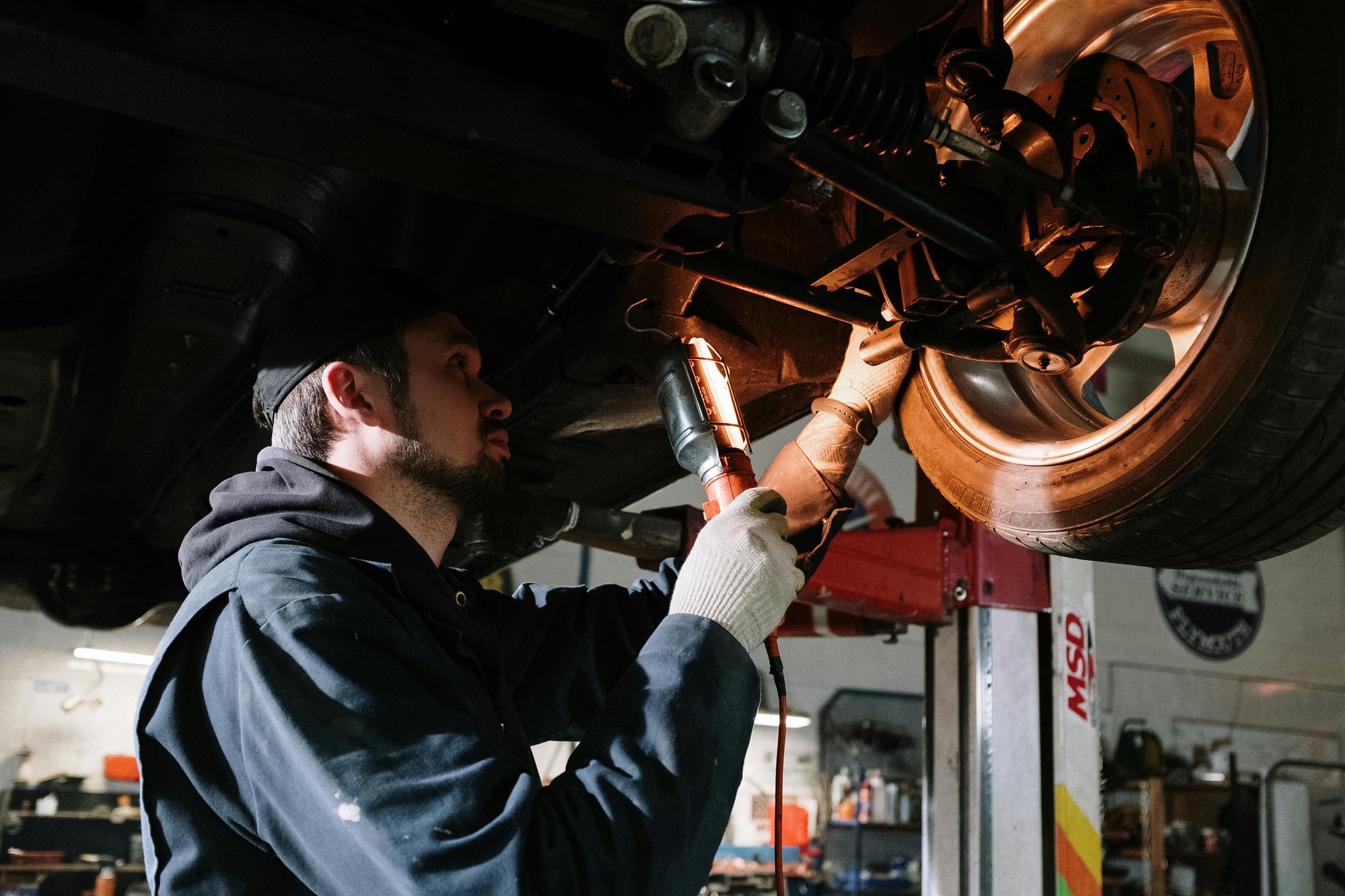 Mechanic looking under car in the wheel well